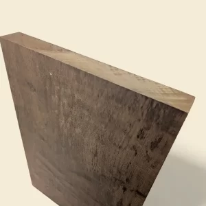 Brazilian Walnut Imbuia guitar body blank on linen backdrop, chocolate-brown heartwood with caramel streaks