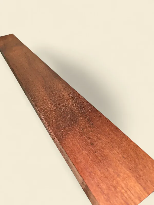Old-growth Khaya Mahogany guitar neck blank full length profile on linen backdrop