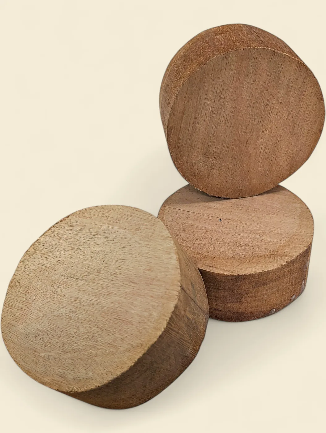 Rose Butternut bowl blank, 115mm diameter - group of blanks showing colour and figure variation, on linen backdrop